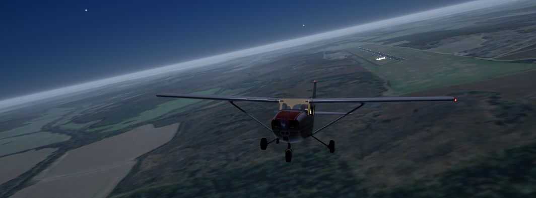 A high-wing aircraft approaching a distant runway over open country at dusk